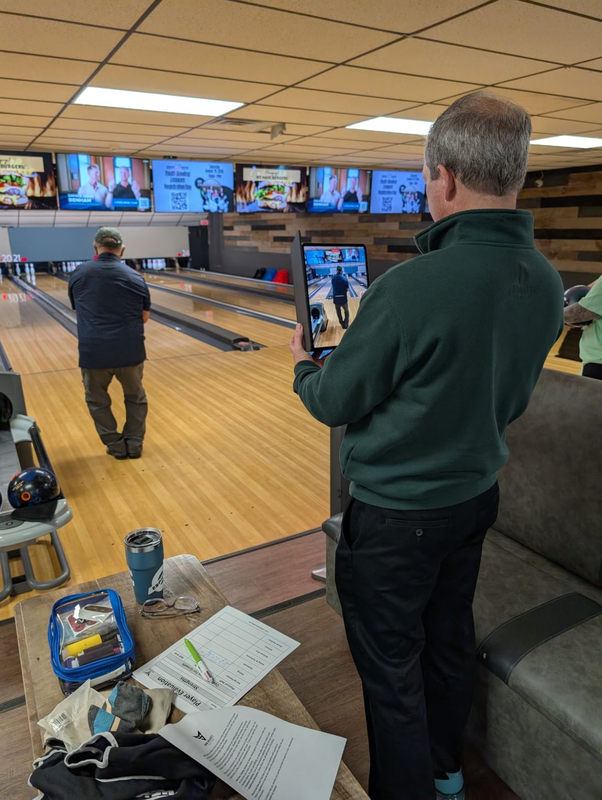 Mike Shady filming a bowler from behind on a tablet